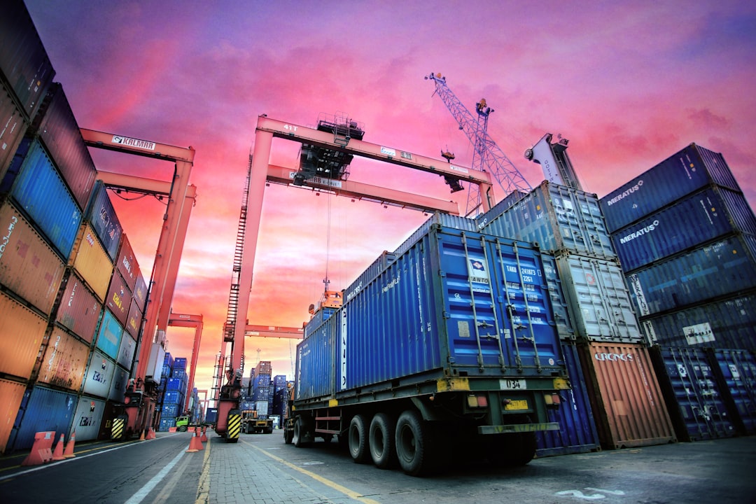 shipping-containers-stacked-at-a-busy-port-at-sunset-ft4swa83jh4